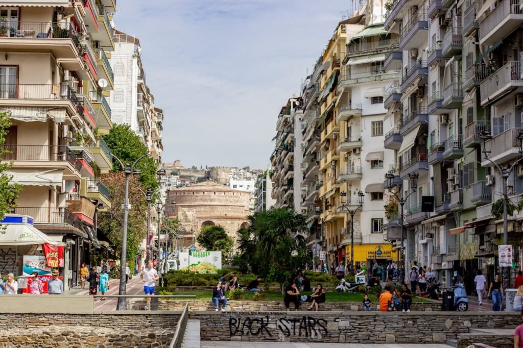Bustling street scene in Thessaloniki, Greece with historic Rotunda in the background.