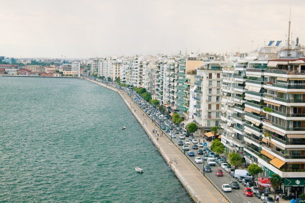 Aerial view of a bustling waterfront with high-rise buildings lining the street, showcasing urban life.