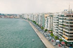 Aerial view of a bustling waterfront with high-rise buildings lining the street, showcasing urban life.